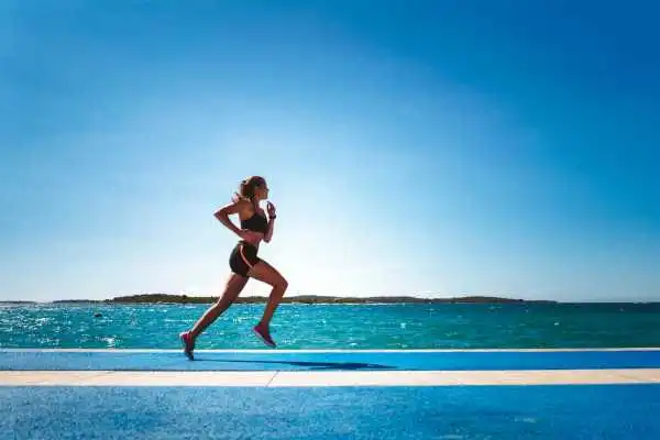 Woman running showing strong leg muscle Kent